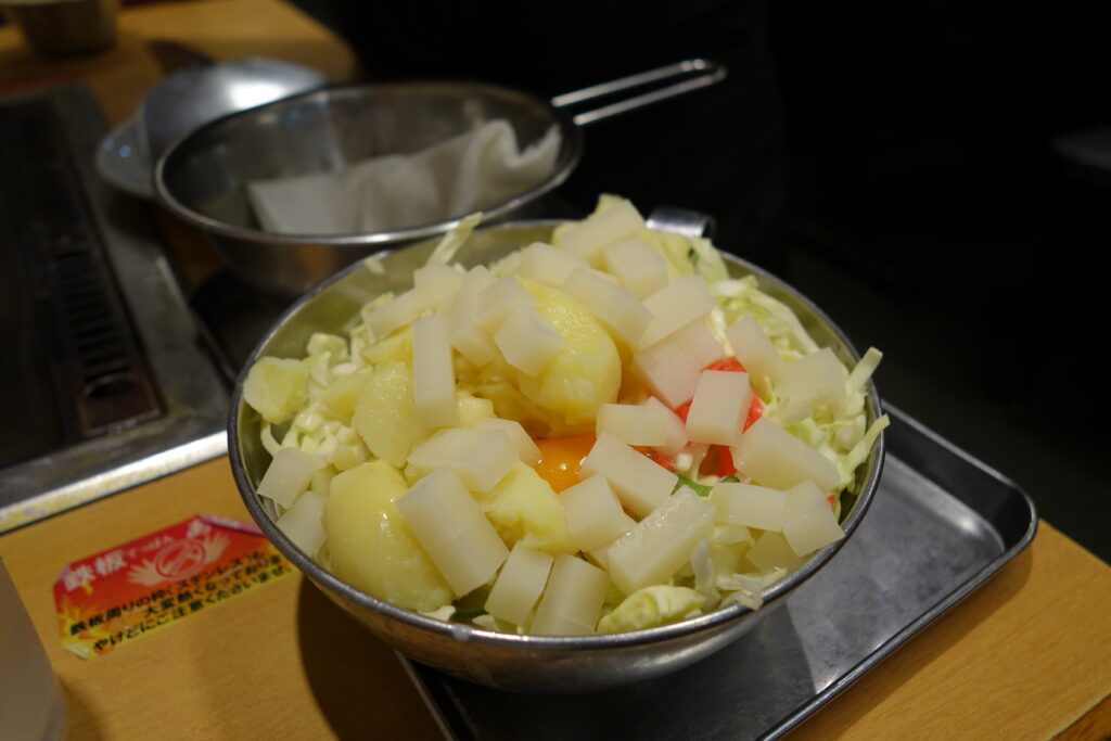 The staff bring a bowl of the okonomiyaki mix to the table and ensures that the grill is oiled and at the proper temperature.