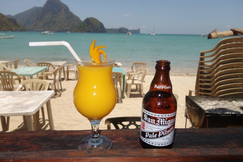 A mango smoothie and a San Miguel Pilsner on the beach in El Nido.