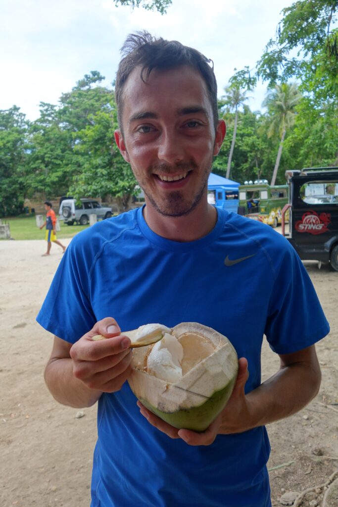 Eating the flesh of a young coconut.