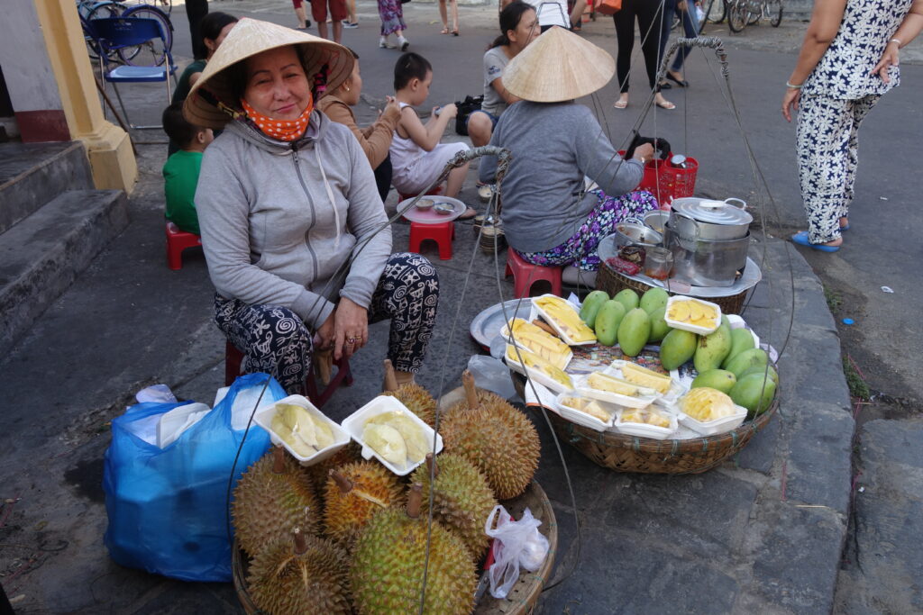 Buying some lobes of durian fruit from a street vendor.