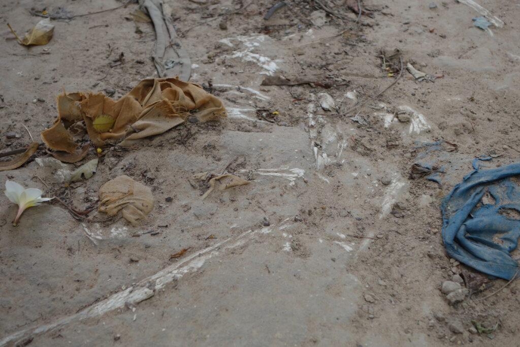 Clothing and bones visible in the soil.