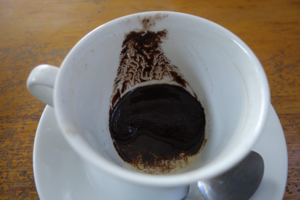 Coffee grounds left at the bottom of a cup.