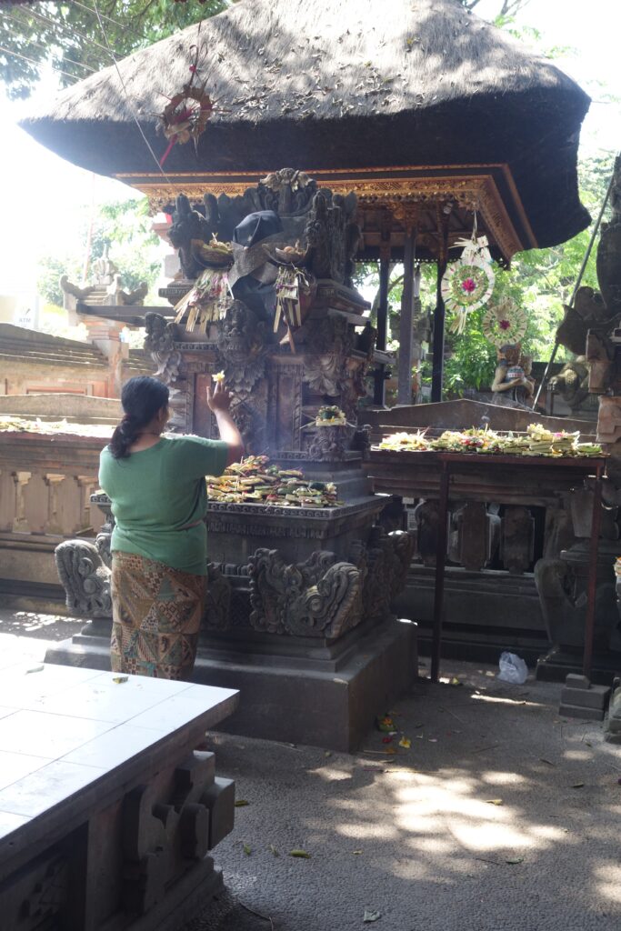 A woman makes an offering at a temple in Ubud.